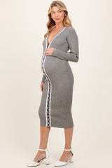 woman wearing a grey ribbed maternity dress with a deep v-neck and button details, showcasing her baby bump