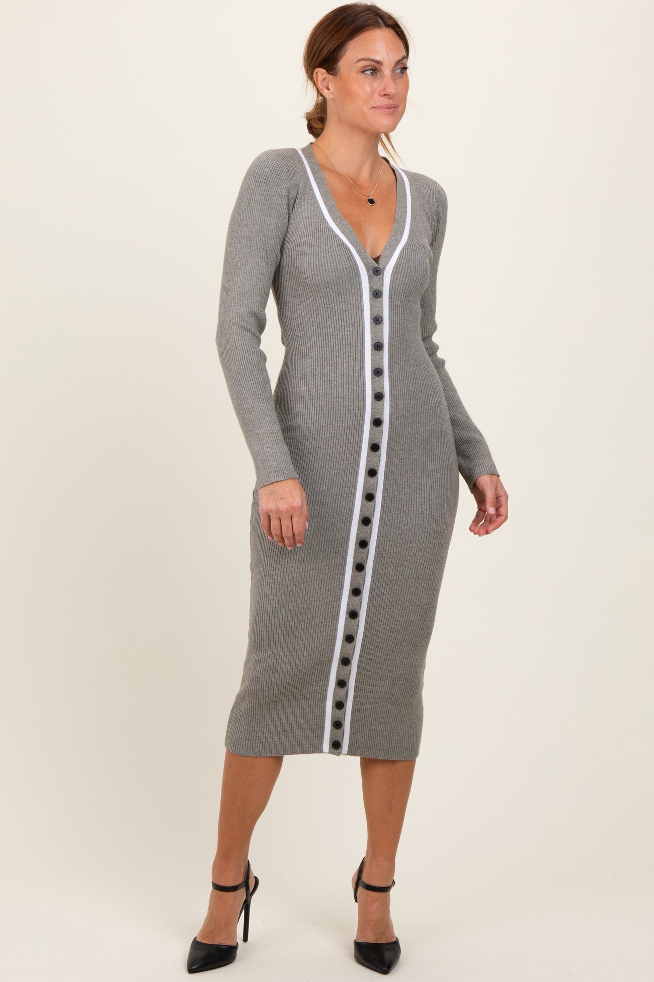 woman wearing a gray ribbed midi dress with a white button-down front and long sleeves, paired with high heels