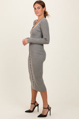 woman wearing a grey ribbed midi dress with a deep V-neck and side stripes, styled with black strappy heels