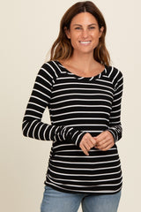 woman wearing a black and white striped long sleeve top with a scoop neckline and fitted style