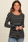 woman wearing a black and white striped long sleeve top with a scoop neckline and fitted style