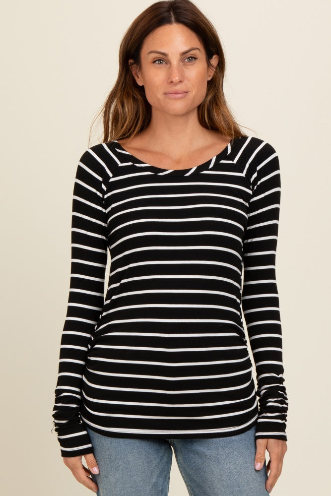 woman wearing a black and white striped long sleeve top with a scoop neck and fitted style