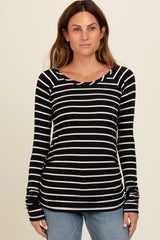 woman wearing a black and white striped long sleeve top with a scoop neck and fitted style
