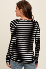 woman wearing a black and white striped long sleeve top, displaying the back view with fitted design and crew neckline