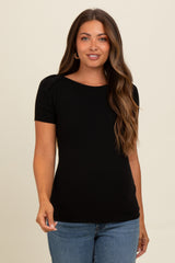 woman wearing a black short sleeve ribbed maternity top with a fitted silhouette and a round neckline
