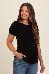 woman wearing a black ribbed maternity top with short sleeves and a visible baby bump