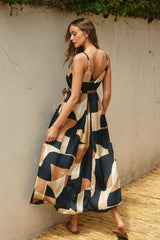 woman wearing a color-blocked maxi dress with a cut-out back and spaghetti straps, standing outdoors