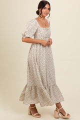 woman wearing a cream floral maxi dress with puff sleeves and a square neckline