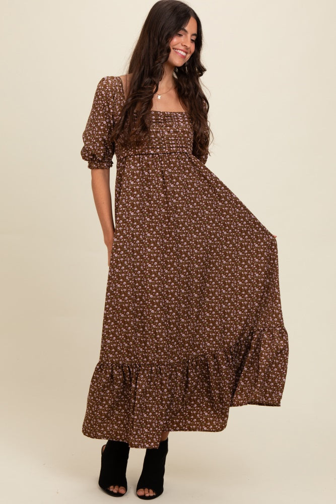 woman wearing a brown floral off-the-shoulder maxi dress with puff sleeves and a tiered hemline
