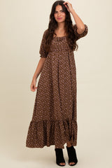 woman wearing a brown floral maxi dress with puff sleeves and a ruffled hem