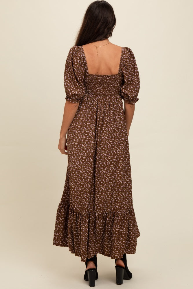 woman wearing a brown floral maxi dress with puff sleeves and a smocked back, standing with her back to the camera