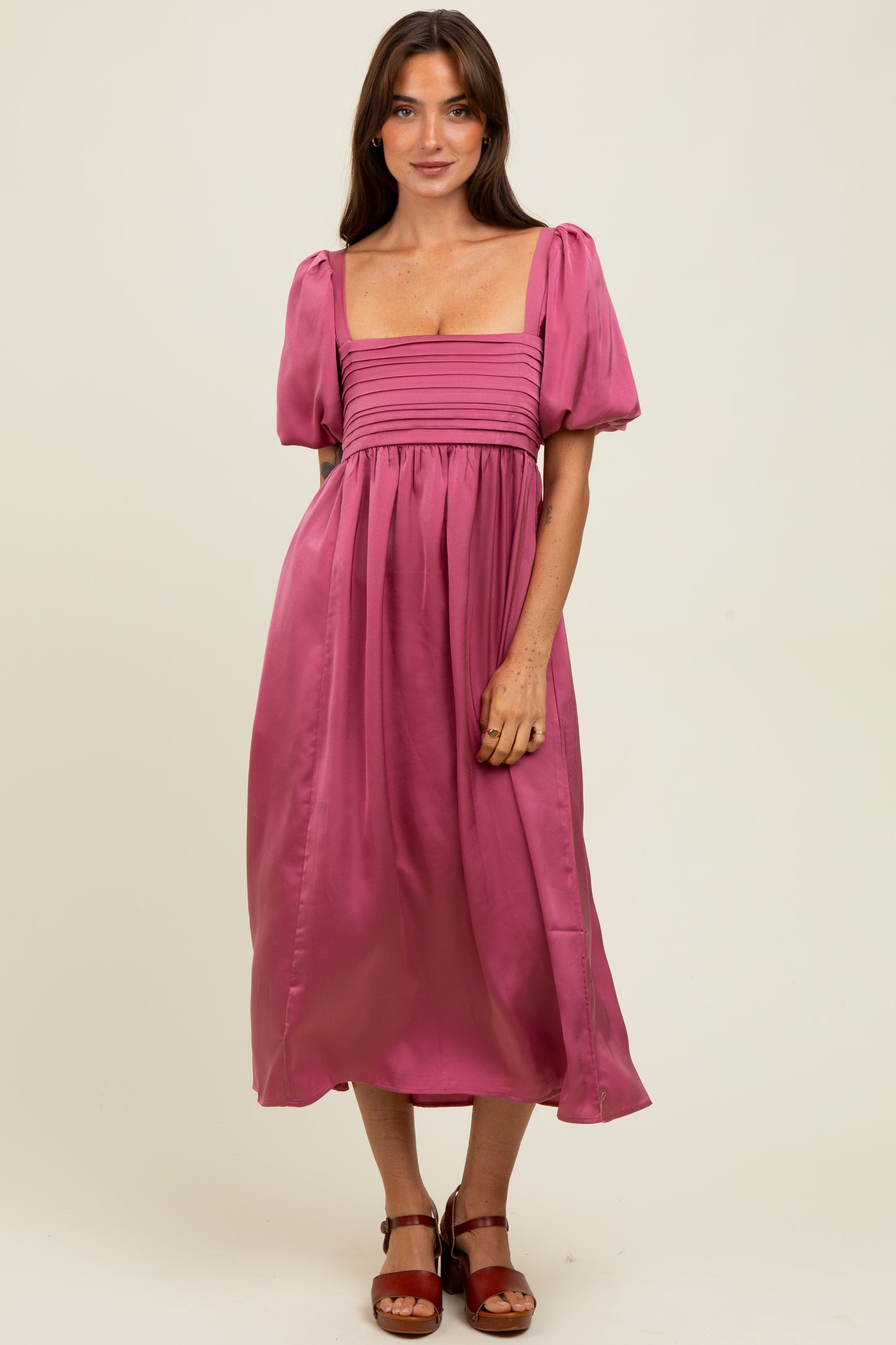 woman wearing a pink puff sleeve midi dress with a square neckline and gathered bodice