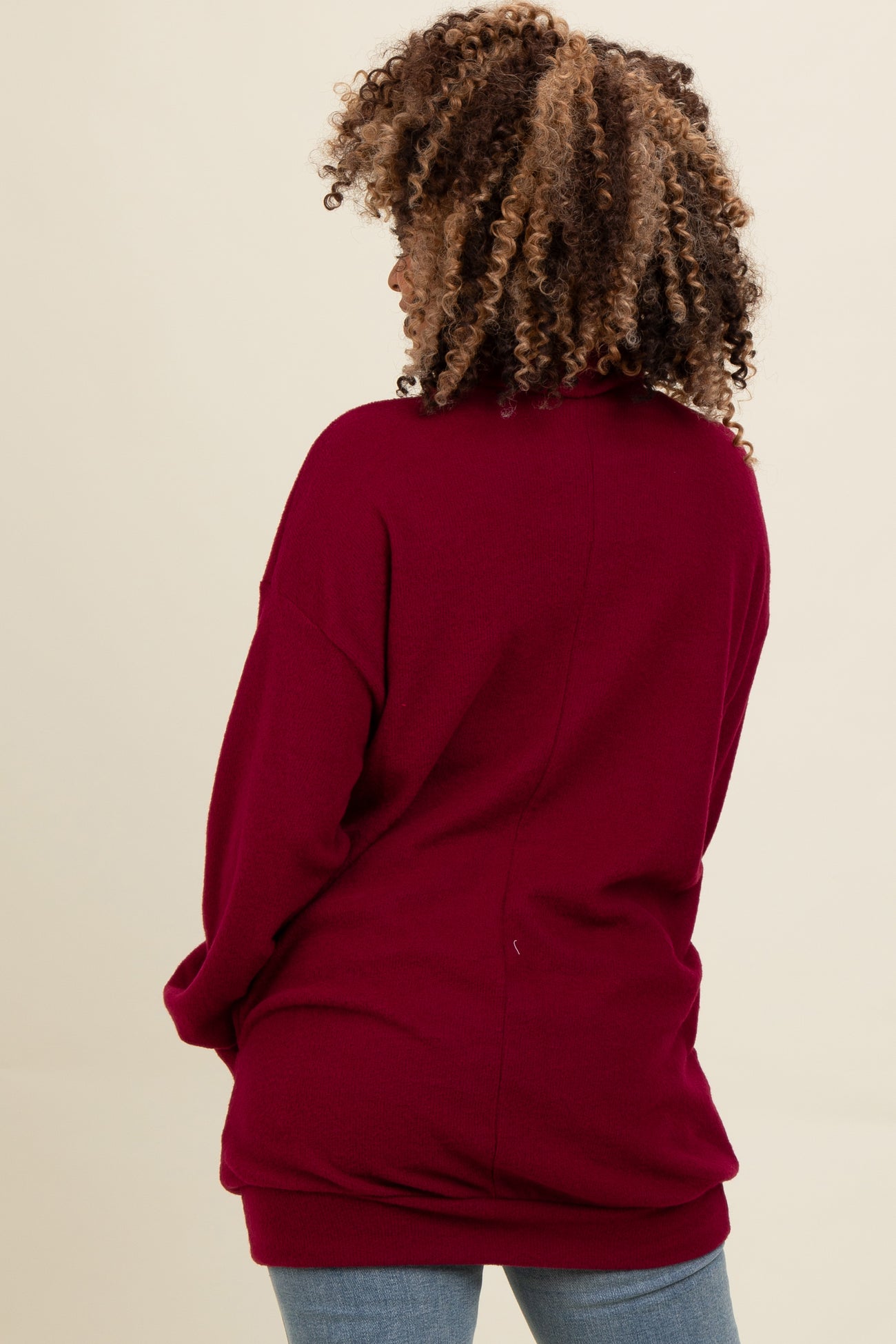 woman wearing a burgundy oversized sweater with a relaxed fit, viewed from the back