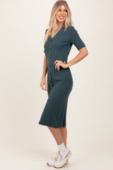 woman wearing a teal ribbed midi dress with short sleeves and buttons down the front, styled with white sneakers