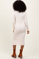 woman wearing a light beige ribbed midi dress with long sleeves and brown ankle boots, seen from the back