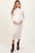 woman wearing a cream ribbed maternity dress with long sleeves and a visible baby bump