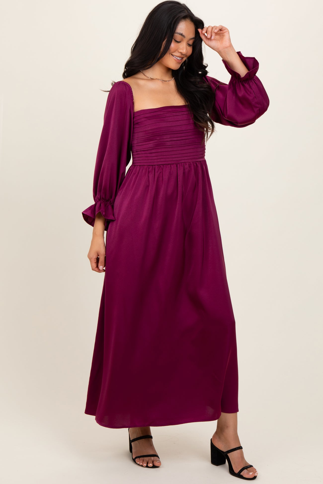 woman wearing a deep magenta long sleeve maxi dress with a square neckline and puffed sleeves