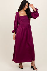 woman wearing a deep magenta long sleeve maxi dress with a square neckline and puffed sleeves