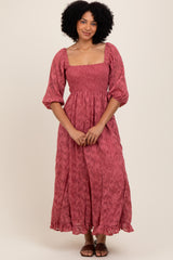 woman wearing a pink floral maxi dress with puff sleeves and a square neckline, standing with hands clasped in front