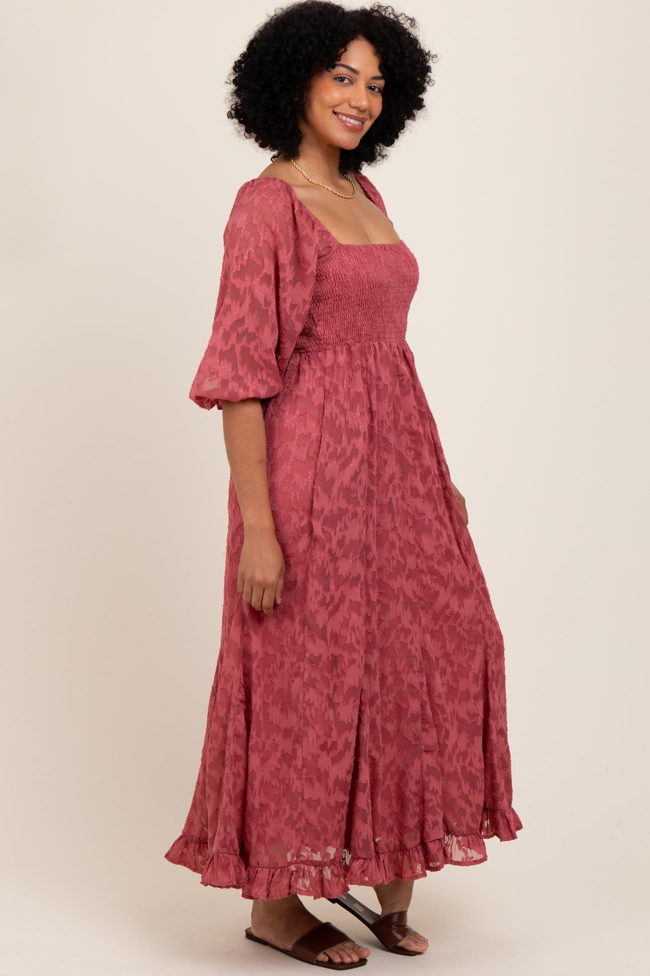 woman wearing a raspberry pink maxi dress with puff sleeves and a smocked bodice