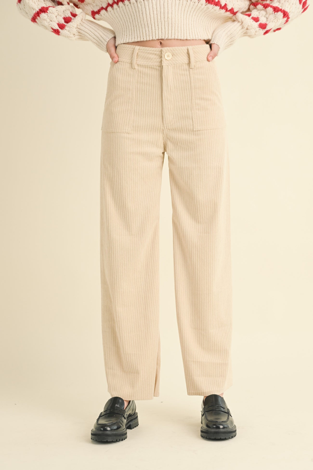 woman wearing cream corduroy wide-leg pants styled with a cozy knit sweater and black platform shoes