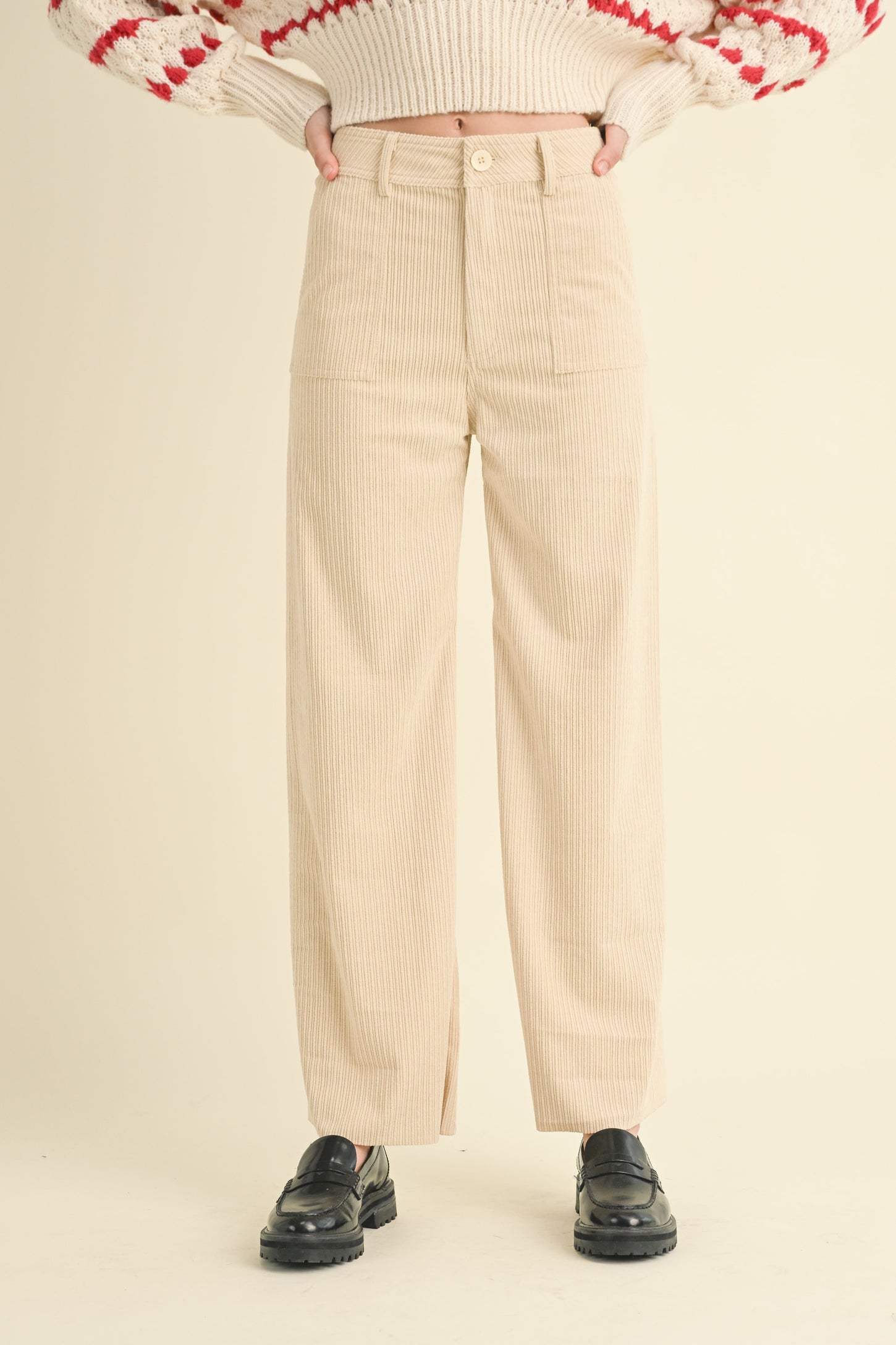 woman wearing cream corduroy wide-leg pants styled with a cozy knit sweater and black platform shoes