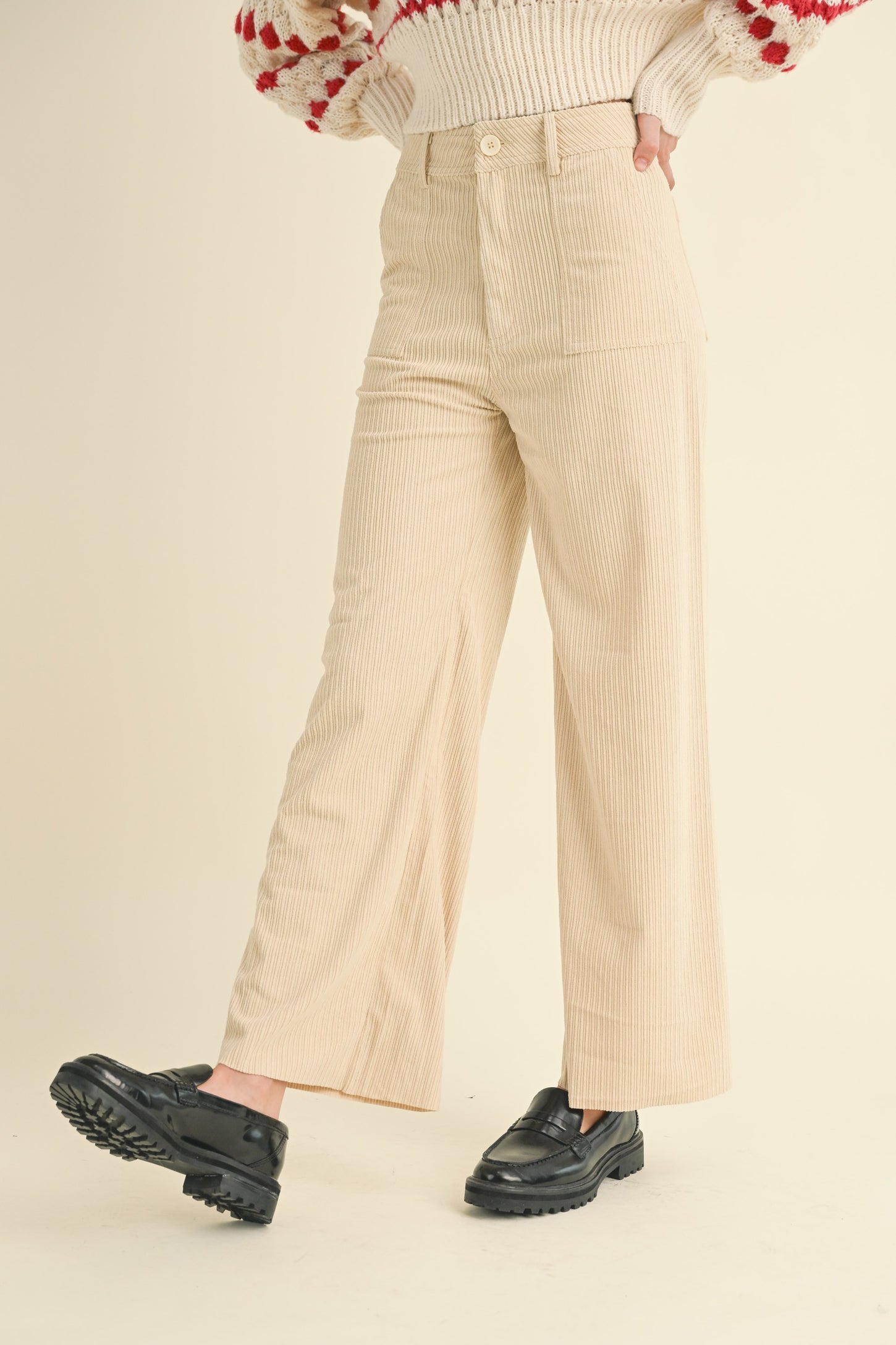 woman wearing a cream-colored corduroy wide-leg pants and black chunky loafers.