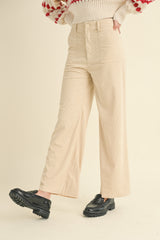 woman wearing a cream-colored corduroy wide-leg pants and black chunky loafers.