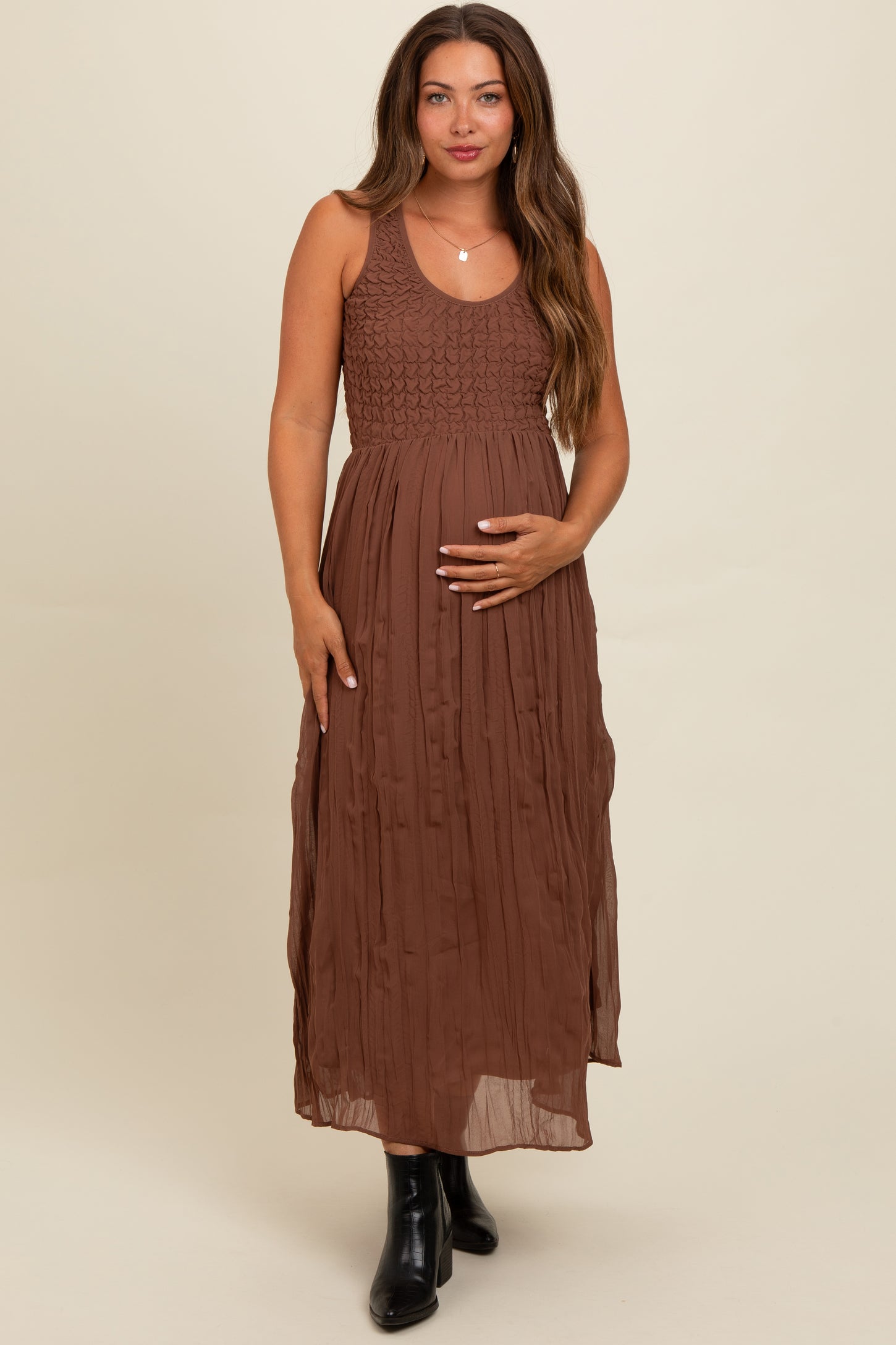 woman wearing a brown maternity maxi dress with a smocked bodice and a baby bump visible