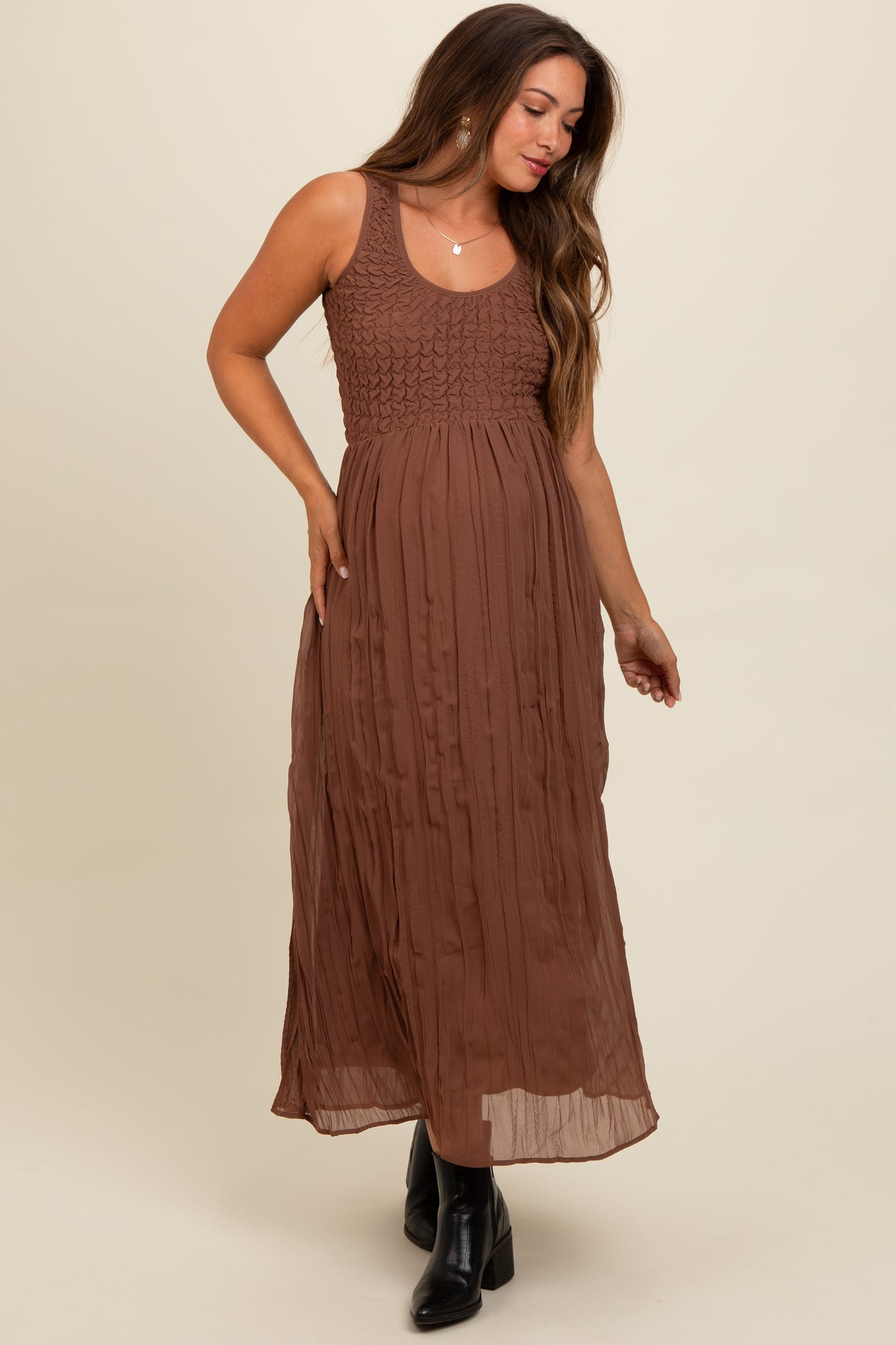 woman wearing a brown maternity maxi dress with a smocked bodice and flowing skirt