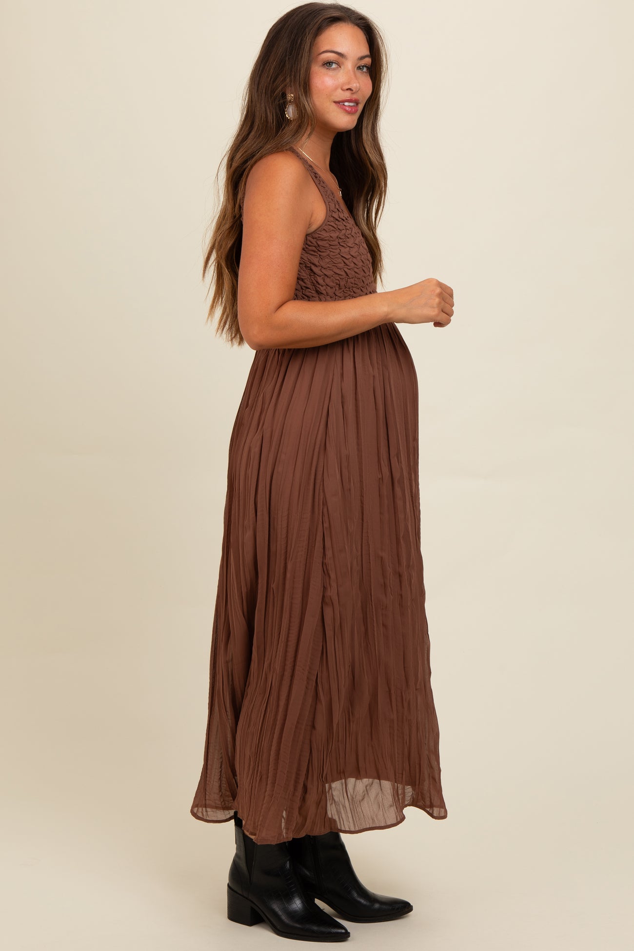 woman wearing a brown maternity maxi dress with smocked bodice and a visible baby bump