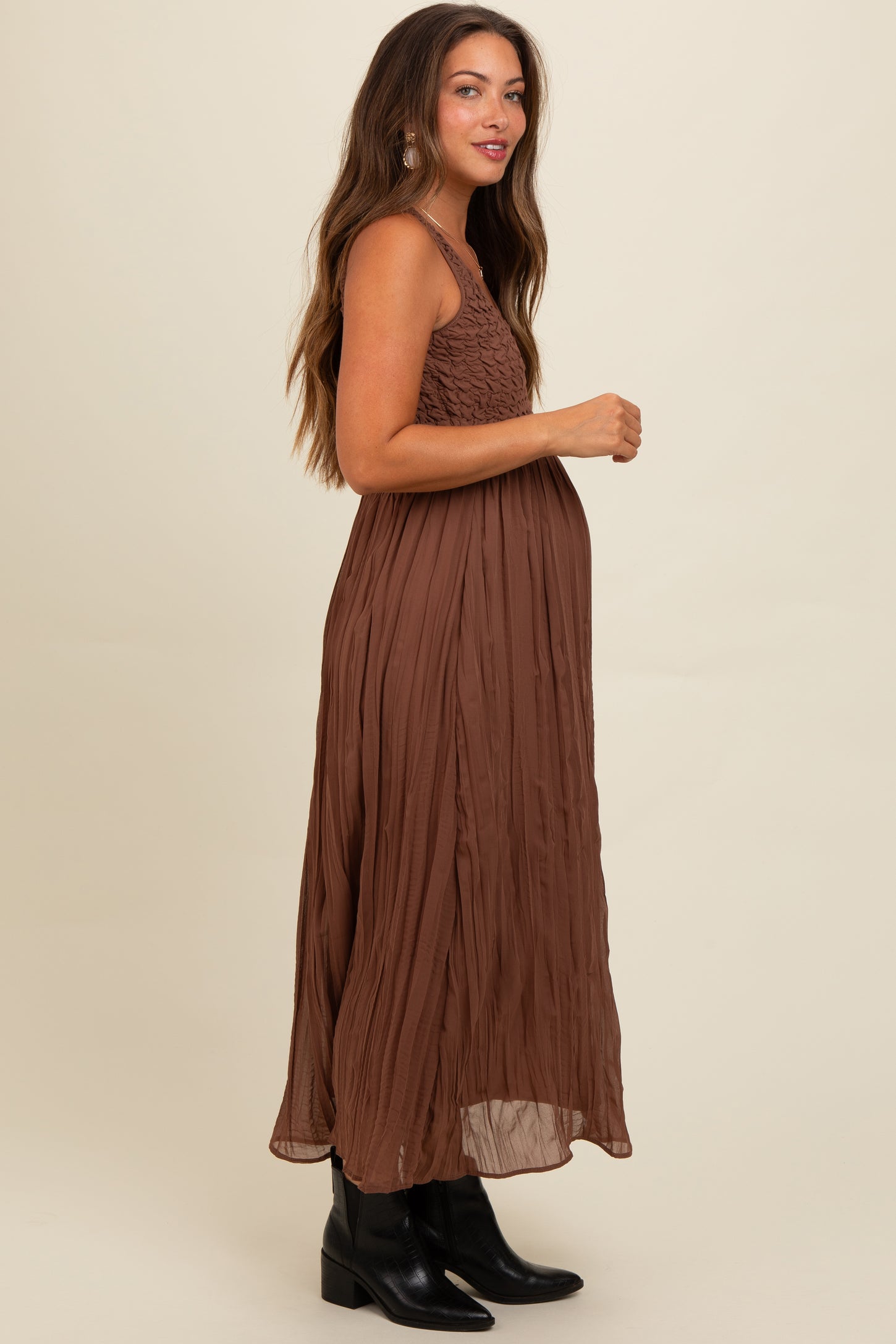 woman wearing a brown maternity maxi dress with smocked bodice and a visible baby bump