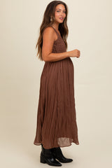 woman wearing a brown maternity maxi dress with smocked bodice and a visible baby bump