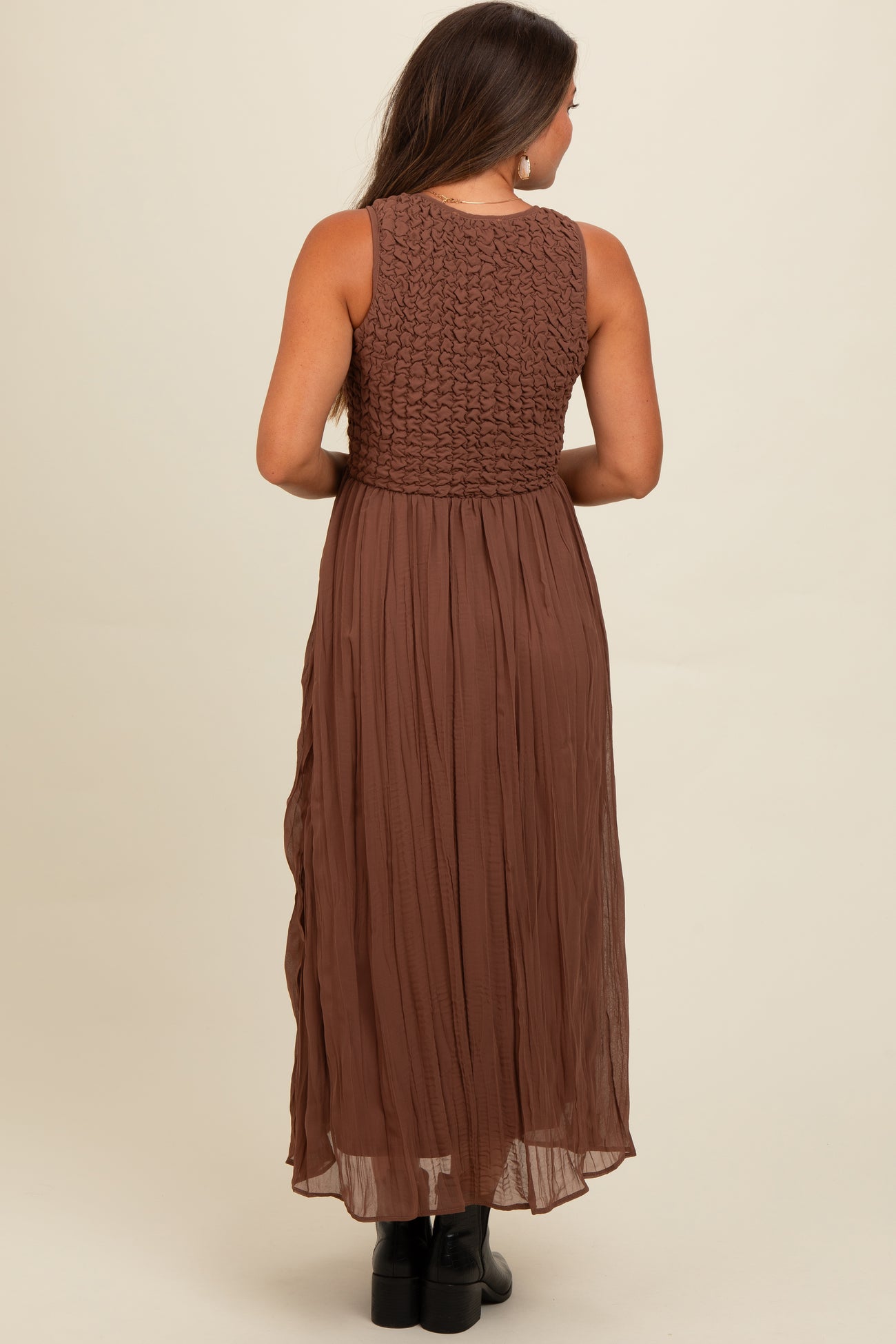 woman wearing a brown maternity maxi dress with a smocked bodice and flowing skirt, viewed from the back
