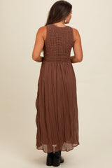 woman wearing a brown maternity maxi dress with a smocked bodice and flowing skirt, viewed from the back