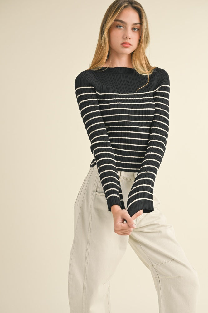 woman wearing a black and white striped ribbed long sleeve top with fitted design and cream-colored wide leg pants