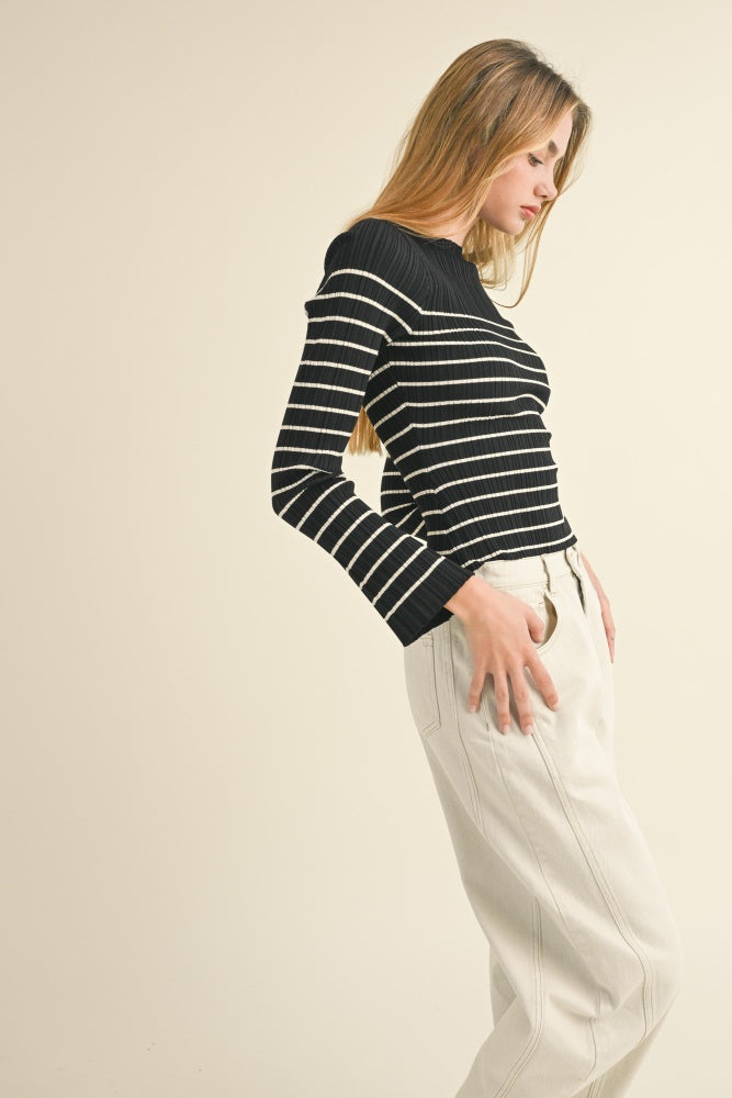 woman wearing a black and white striped ribbed long sleeve top and cream-colored wide-leg pants