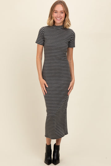 woman wearing a gray and white striped short sleeve midi dress styled with black ankle boots