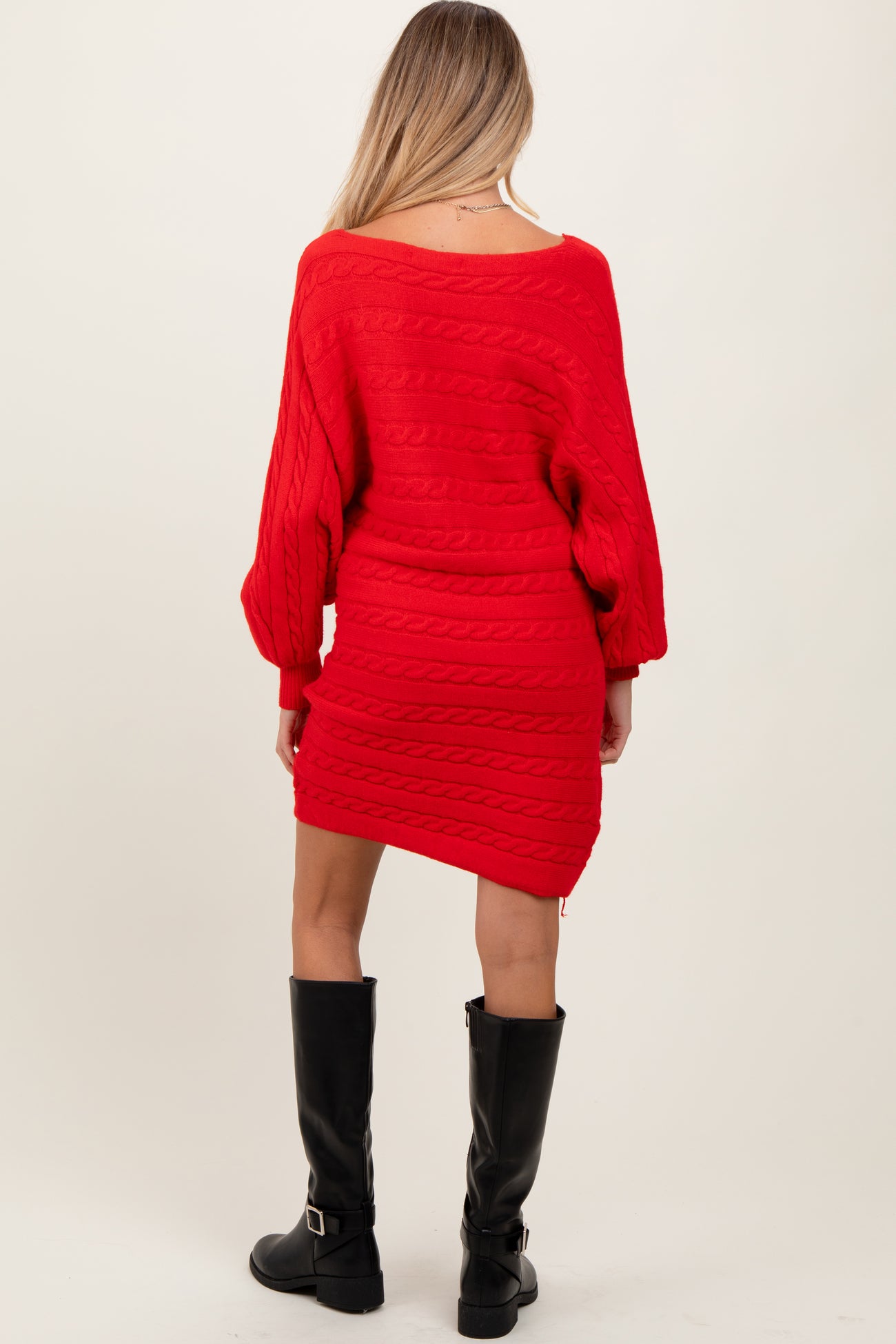 woman wearing a bright red cable knit maternity dress with long sleeves and a fitted silhouette