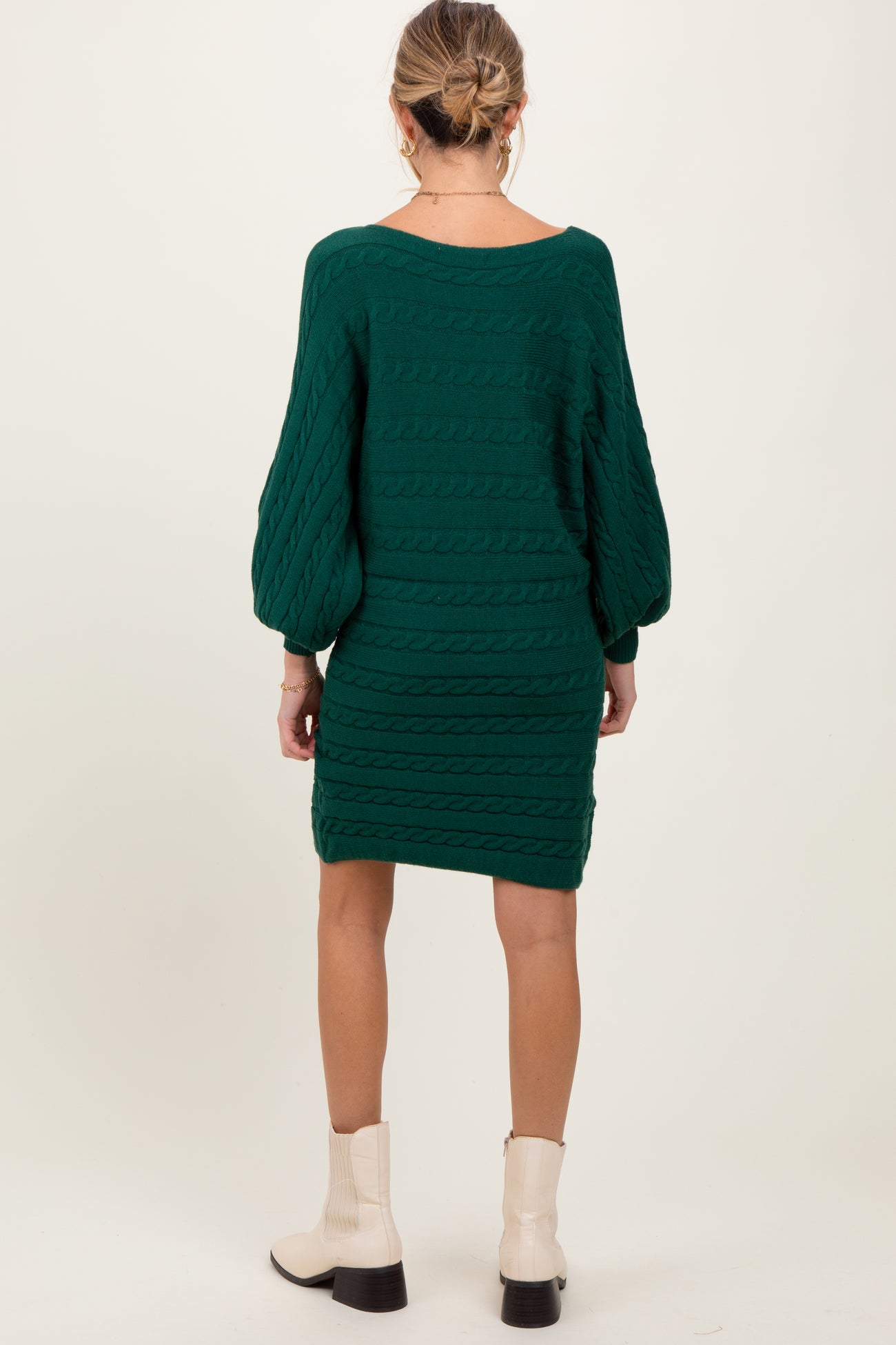 woman wearing a dark green cable knit maternity sweater dress with long sleeves and a relaxed fit
