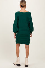 woman wearing a dark green cable knit maternity sweater dress with long sleeves and a relaxed fit