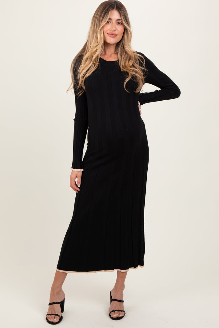woman wearing a black ribbed maternity dress with long sleeves and a fitted silhouette, showcasing her baby bump
