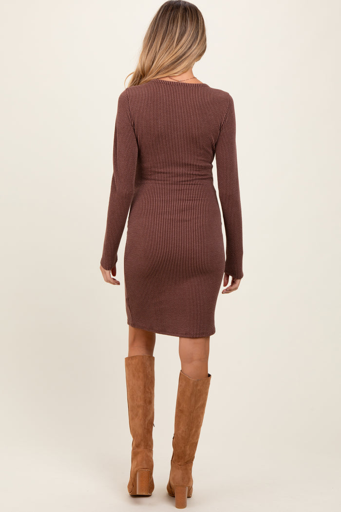 woman wearing a brown ribbed long sleeve maternity dress, seen from the back, with knee-high tan boots