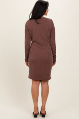 woman wearing a long sleeve brown ribbed dress with a fitted silhouette and reaching just above the knees