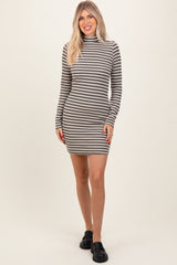 woman wearing a gray and white striped long sleeve mini dress with a high neck and black sneakers