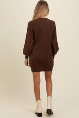 woman wearing a brown oversized maternity sweater dress with balloon sleeves and a relaxed fit, viewed from the back