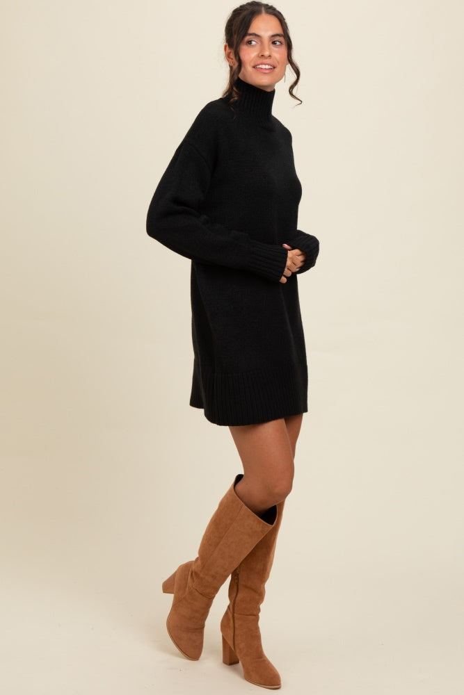 woman wearing a black turtleneck sweater dress with long sleeves and knee-high beige boots