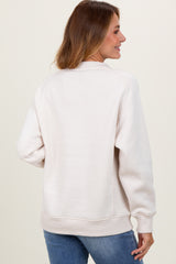 woman wearing a light beige oversized sweatshirt with ribbed hem and cuffs, shown from the back