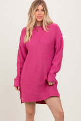 woman wearing a bright pink oversized sweater dress with long sleeves and side slits