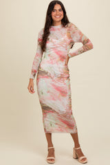 woman wearing a long sleeve pastel marble print midi dress and pink heeled sandals